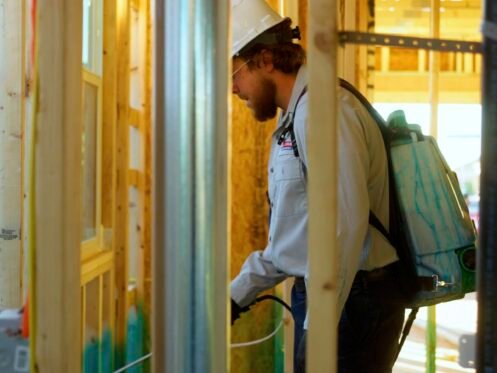 Man sprays wall frame